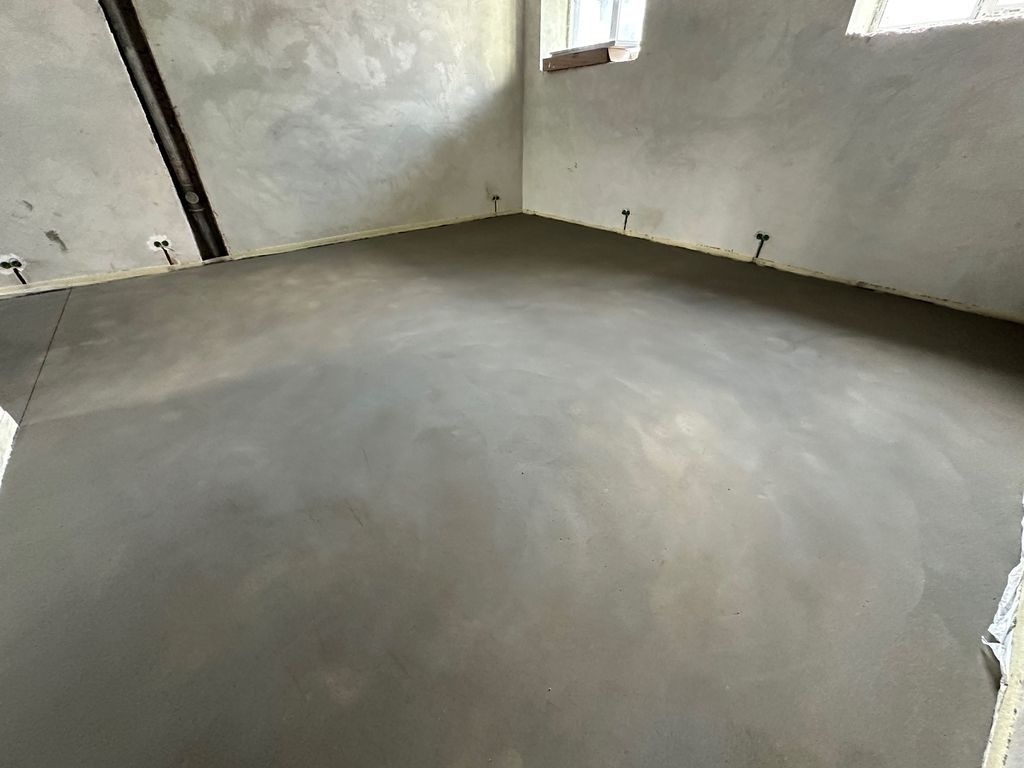 Chape fluide grise lissee sur sol interieur a Bordeaux, coulage et finition realises par MC Carreleur.