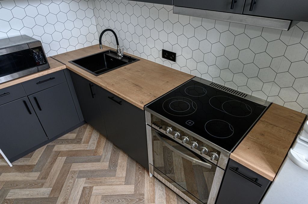 Cuisine a Saint-Andre-de-Cubzac avec credence mosaique hexagonale et sol effet bois, pose par MC Carreleur.