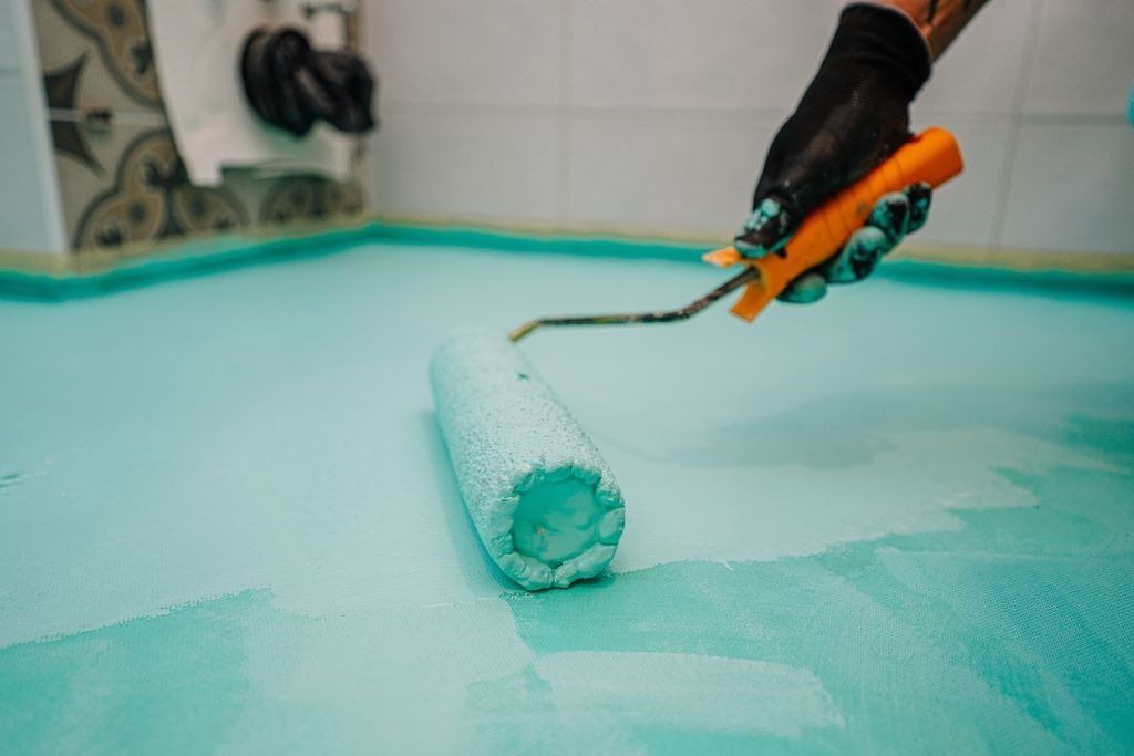 Application d une membrane d etancheite liquide bleu turquoise au rouleau a Libourne par MC Carreleur.