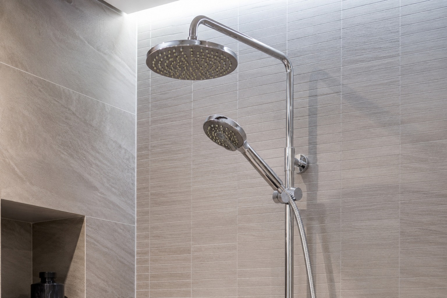 Colonne de douche pluie chromée avec douchette sur carrelage pierre beige – MC Carreleur Libourne Gironde