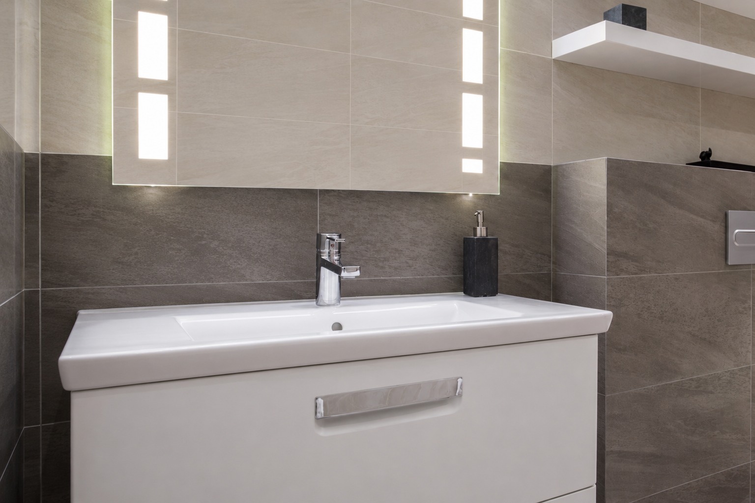 Meuble vasque flottant blanc et miroir LED éclairé sur carrelage gris – MC Carreleur salle de bain Izon