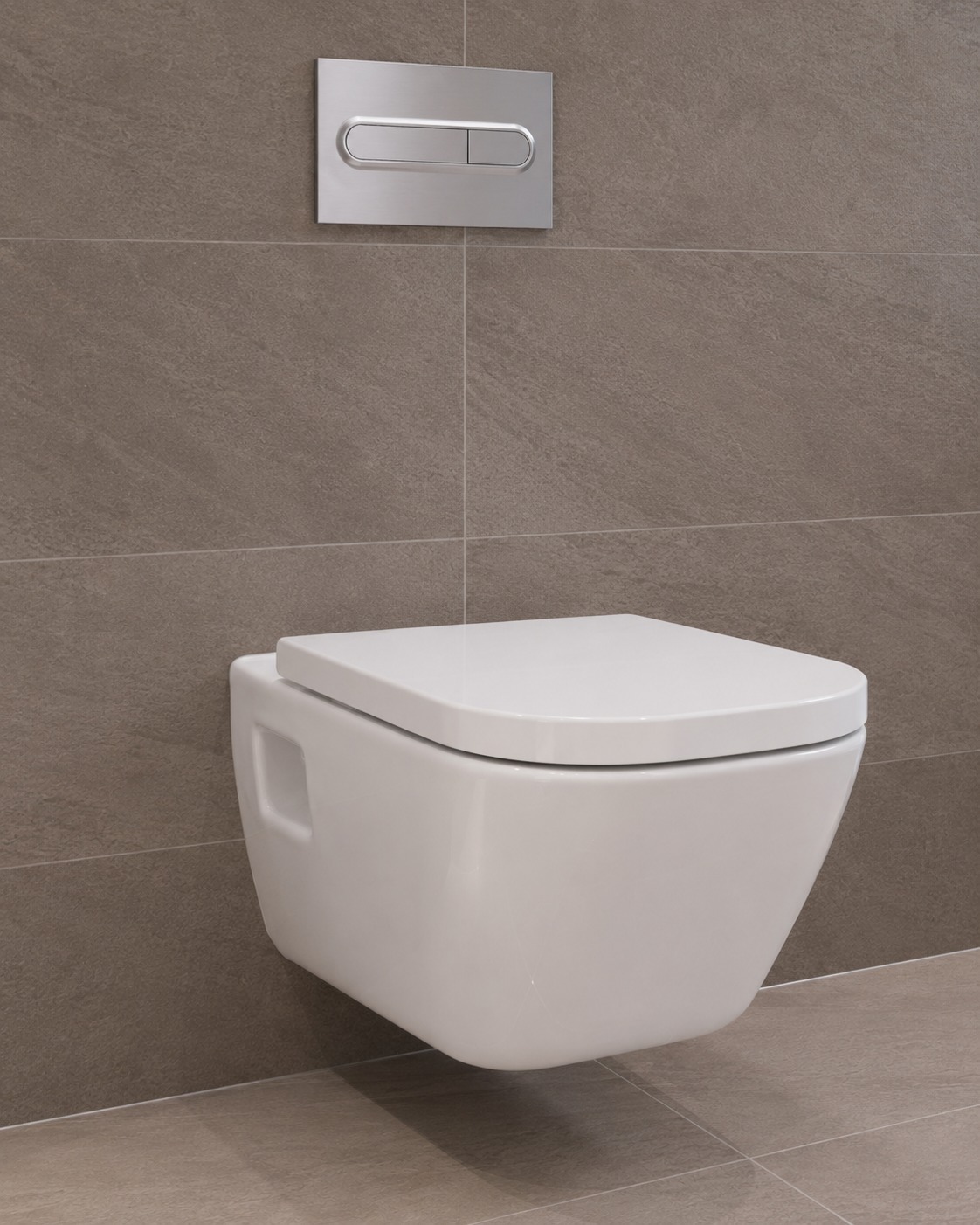WC suspendu blanc avec plaque de commande chrome sur carrelage gris anthracite – MC Carreleur Izon Gironde