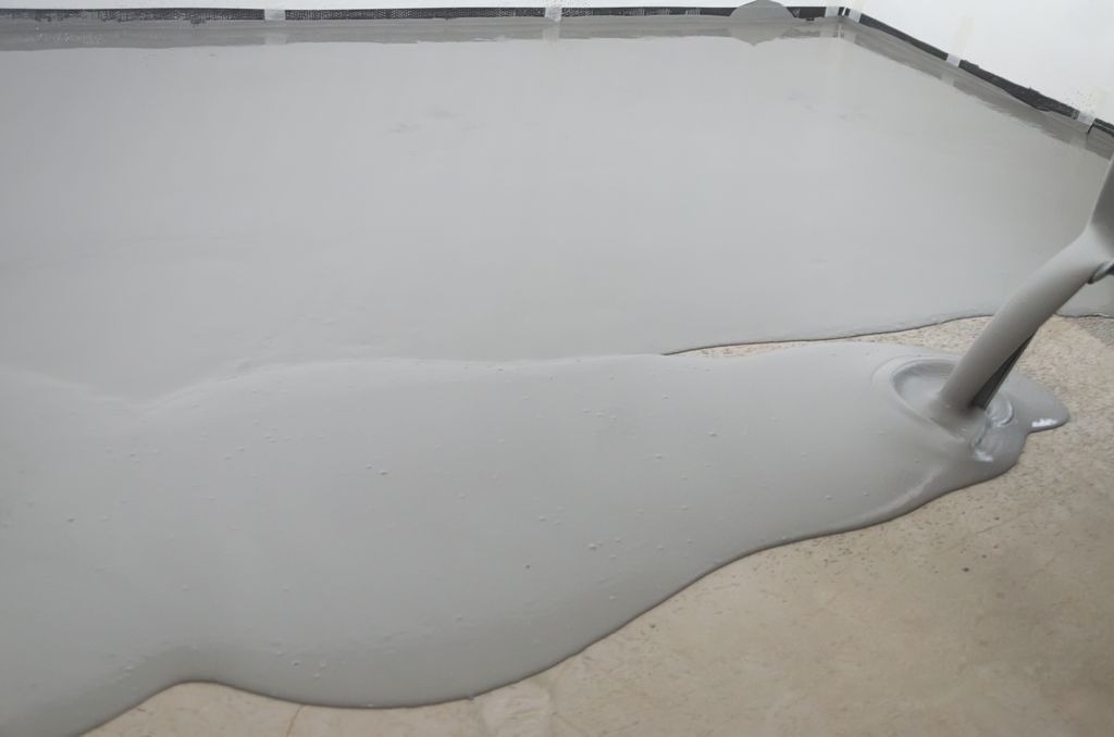 Coulee d un ragreage autolissant gris sur chape brute a Libourne par MC Carreleur, preparation avant pose carrelage.