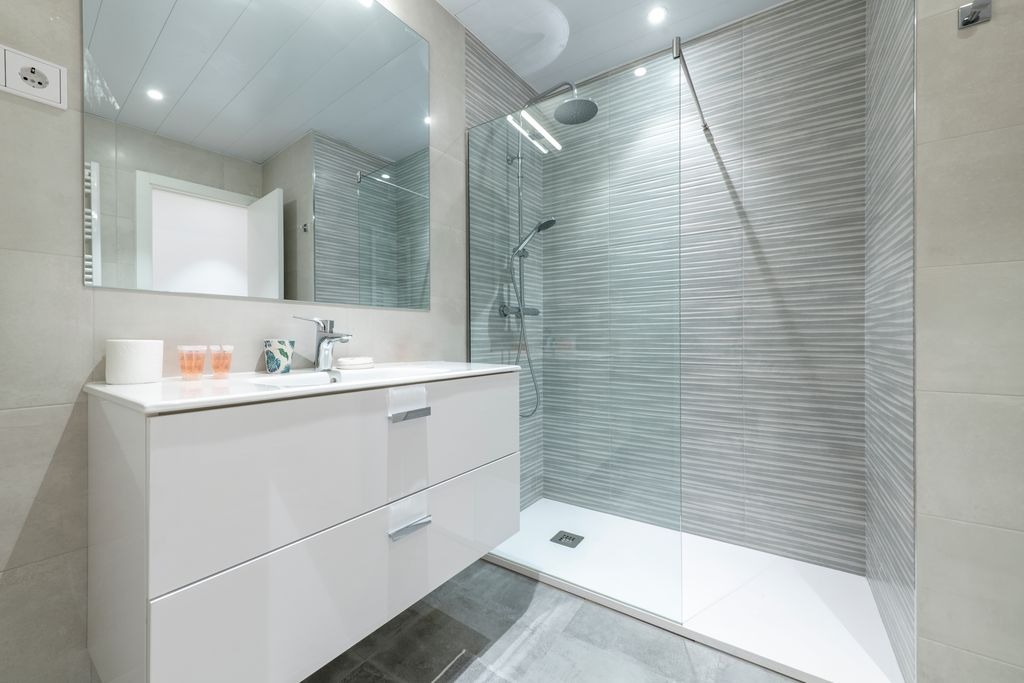 Salle de bain moderne avec douche italienne et carrelage realisee par MC Carreleur a Izon, interieur epure.