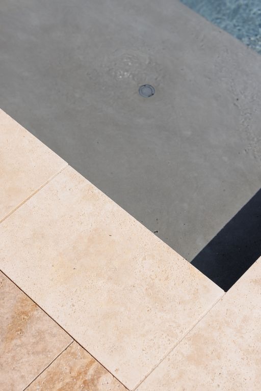 Margelles de piscine en travertin beige a Izon par MC Carreleur, finition naturelle et joints precis en angle.