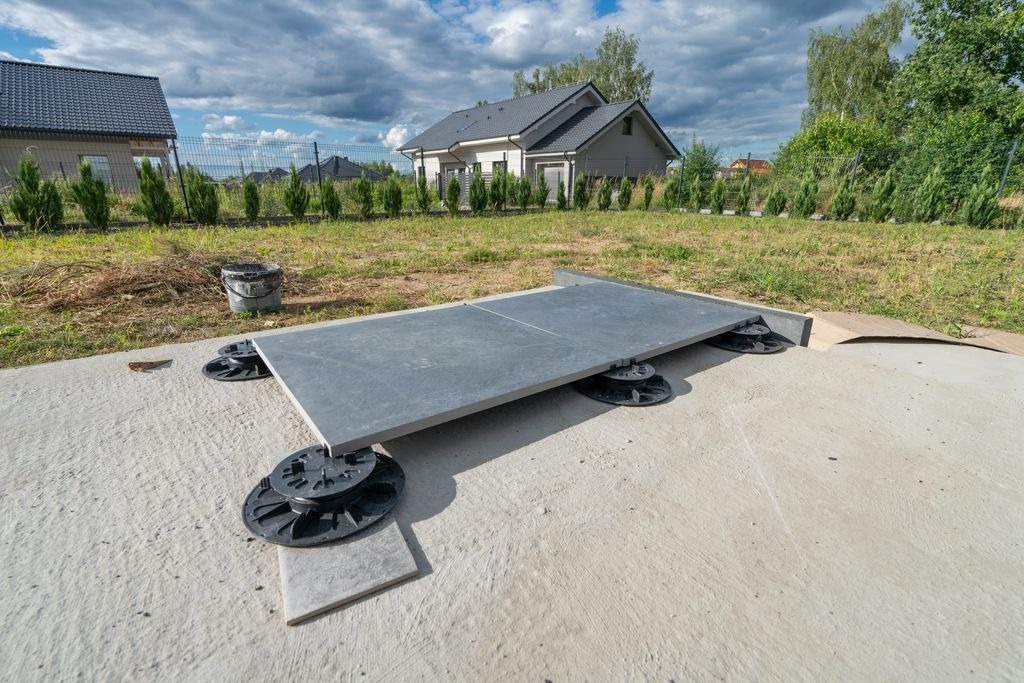 Pose de dalles anthracite sur plots reglables pour terrasse exterieure a Libourne, chantier par MC Carreleur.