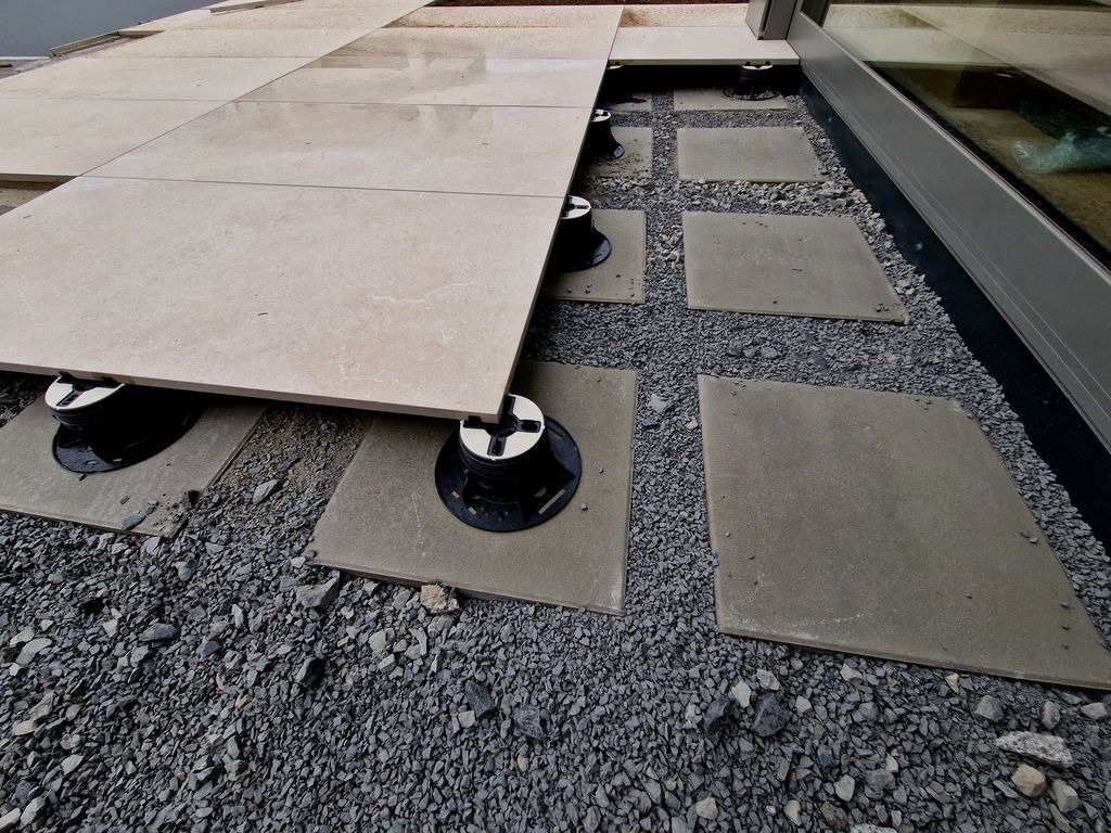 Dalles beige sur plots reglables, pose de terrasse sur gravier a Saint-Andre-de-Cubzac, chantier par MC Carreleur.